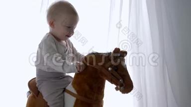 幼<strong>儿时</strong>期，快乐的小男孩在家中骑着玩具马